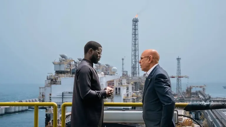Échange sur une passerelle de la plateforme gazière GTA, devant l’unité flottante de production, lors de la visite du 22 mai 2025