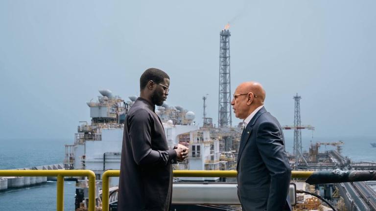 Échange sur une passerelle de la plateforme gazière GTA, devant l’unité flottante de production, lors de la visite du 22 mai 2025